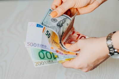 A woman holding a variety of currency.